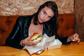 Beautiful Young Brunette Woman Eating a Hamburger