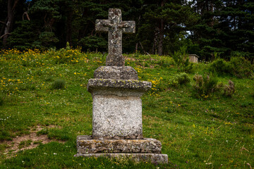Stone cross or memorial in meadow , lozere , france.