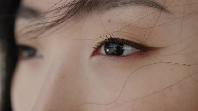 Eyes of wonderful asian young woman opening and looking straight. Beautiful face of chinese sensitive lady outdoors. Ethnicity. Close-up.