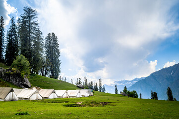 Mountain landscape with green grass. Scenic campingsite on meadows of Himalayan peaks & alpine from...