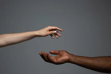 Fotobehang Touch of God. Racial tolerance. Respect social unity. African and caucasian hands gesturing on gray studio background. Human rights, friendship, intenational unity concept. Interracial unity. © master1305