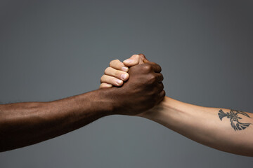 Teamwork. Racial tolerance. Respect social unity. African and caucasian hands gesturing on gray studio background. Human rights, friendship, intenational unity concept. Interracial unity.
