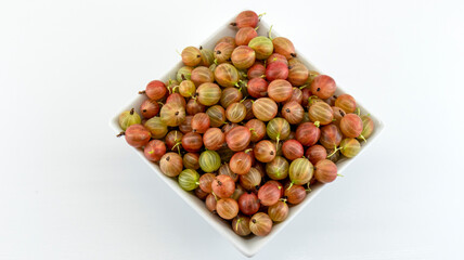 ripe gooseberries in a white plate, macro photography