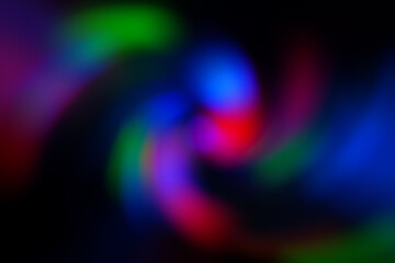 Blurred abstract gradient wave green, pink, blue, blurry christmas and holiday lights background. Multicolored, bright spiral vortex in the dark