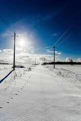 Power line among the snow-covered road