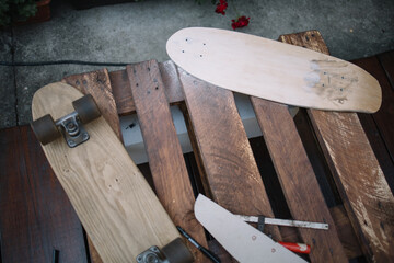 Top view of pallet with skateboard parts and tools. Making skateboard set on wooden table in outdoor workshop.