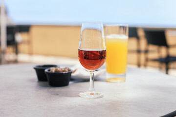 A glass of Madeira wine and a glass of poncha 'Regional' with ice - traditional drink from Madeira in a street cafe. Tasting of local drinks in Funchal