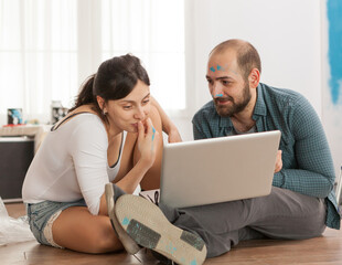 Married couple buying furniture online for their new apartment. Apartment redecoration and home construction while renovating and improving. Repair and decorating.