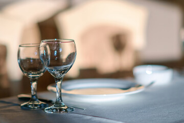 Empty wine glasses on the white table with illuminated background,
