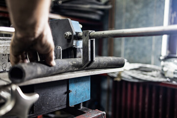 Worker, cutting hydraulic hoses in a metal workshop