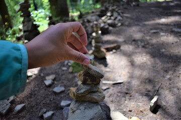Hand placing a stone on a pile during a trekking
