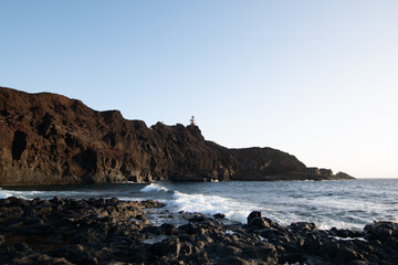 lighthouse on the beach breaking waves