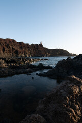 Fototapeta na wymiar lighthouse on the beach breaking waves