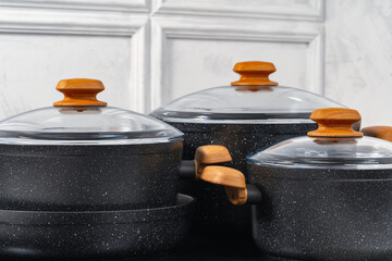 Black cookware on induction stove against grey wall