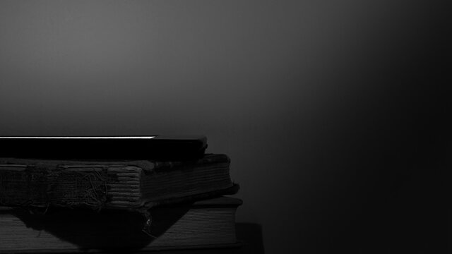 Old Books & E-Reader Stack Black & White Background