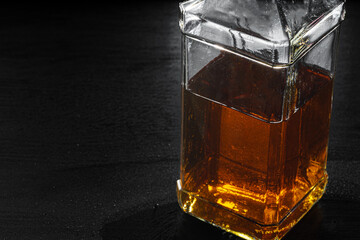 Bottle of whisky on black background, copy space