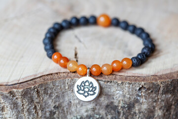 Karneol and lava mineral stone beads bracelet on wooden background