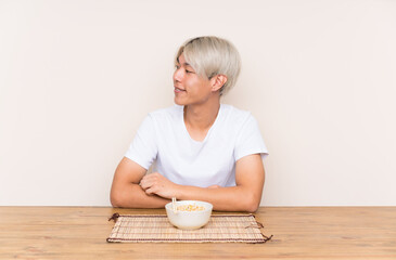 Young asian man with ramen in a table looking to the side