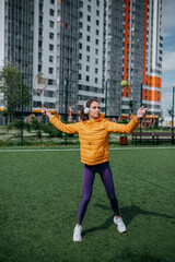 Woman playing on the tennis court. Woman holding tennis racket and ball on the green grass.