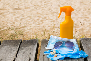 tanning lotion, medical mask and sunglasses, summer vacation concept in the new normal