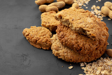 Oat cookies with peanuts on dark background