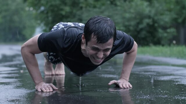 Man do push-ups at rain the street
