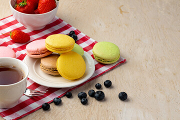 French macaroon cookies of bright colors served in white ceramic plate