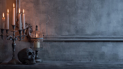 Mystical Halloween still-life background. Skull, candlestick with candles, old fireplace. Horror...