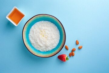 Portion hot of rice porridge in bowl on blue background