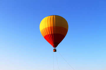 Colorful air balloon flying in the middle of blue sky