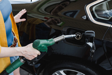 Cropped view of woman refueling car on gas station