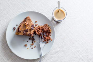 conjunto de un trozo de bizcocho casero con nueces y chocolate junto a un café espresso