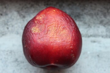 Overripe peach.Dried Peach with rotten, crumpled and wilted skin
wrinkled dried peach on a stone background