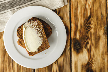 Buttered slice of rye bread on wooden table