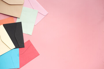 colorful envelope on pink background with copy space.