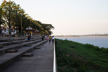 People on a walkway along the mekong at dusk