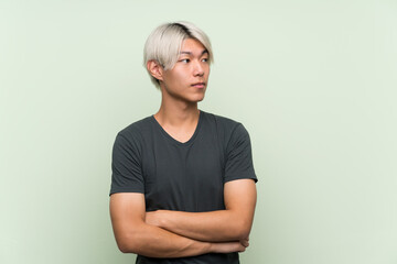 Obraz premium Young asian man over isolated green background portrait