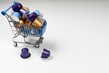 Caffeine, hot drinks and objects concept - close up blue, purple and golden capsules or pods for...