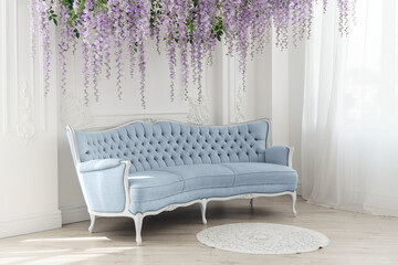 Blue french Sofa in white room with decorative hanged purple flowers