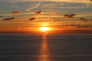 Fototapeta na wymiar Sunset behind clouds over the sea