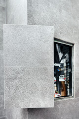 Open hidden revision sanitary hatch on the wall of tile