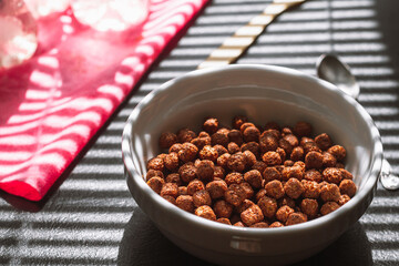 Chocolate breakfast cereal balls shine through the blinds
