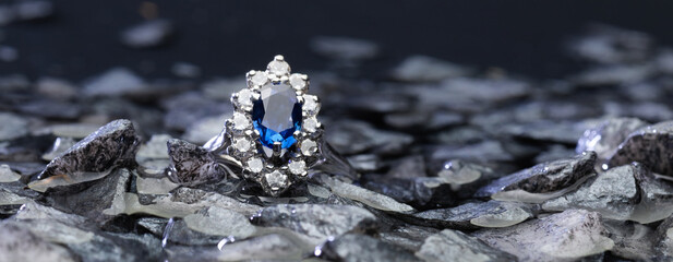 Classy blue gem ring close-up on top of grey stones