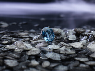 Classy blue gem ring close-up on top of grey stones