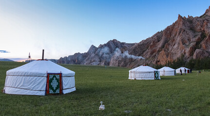 A row of Mongolian gers at a camp at sunset on a summers night