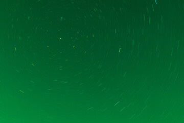 Background of round or circular star track or trajectory on the green clear night sky. Symbol of...