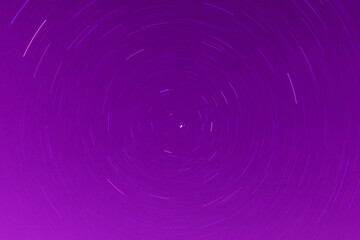 Background of round or circular star track or trajectory on the red, pink or rose clear night sky....