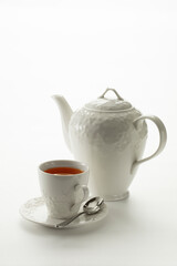Close up view of china teapot and cup on white background