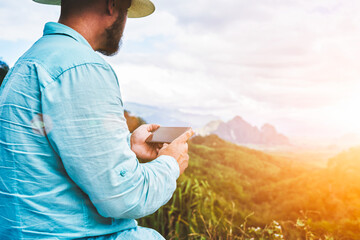 Closely of a man wanderer is holding mobile phone with copy space on the screen for young...
