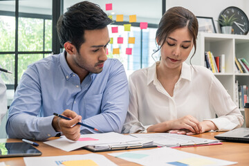 Young business group explaining new business ideas to peers. Business people discussing in meeting room.